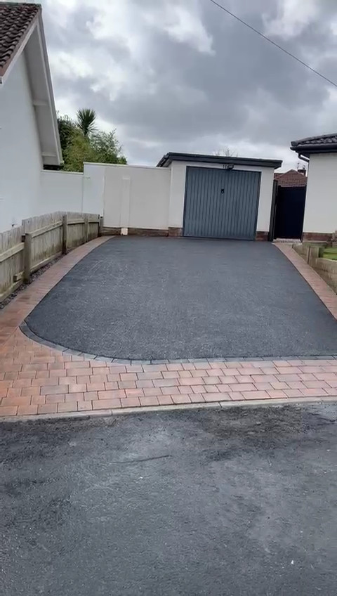 tarmac driveway with sweeping decoratve blockwork inlays.